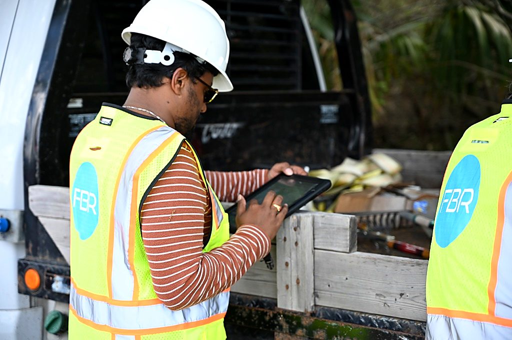 FBR foreman reviewing wireless site plans on a tablet.